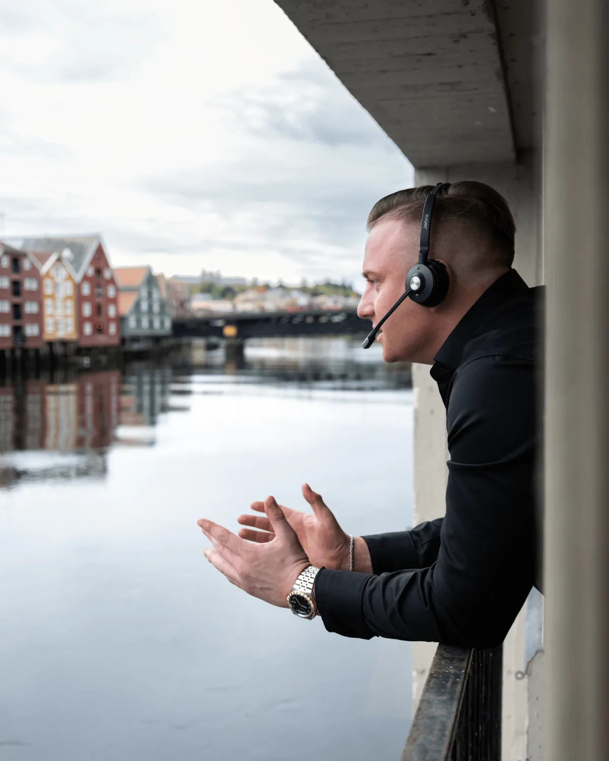 Rådgiver med headset i samtale, med utsikt over elva i Trondheim